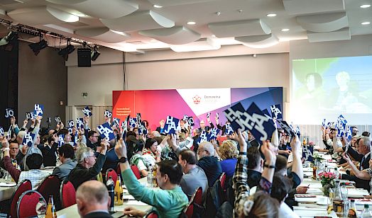 Głowna zgromaźina Domowiny z wjelimi luźimi, kótarež źarže módre toflicki z běłym napisom 