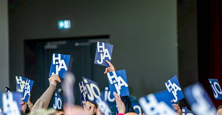 Wjacori dźerža w sydarni módre hłosowanske karty z běłymi pismikami HAJ horje