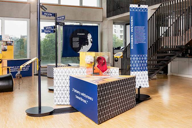 Das sorbische Ausstellungselement greift in seiner Dreiecksform zentrale Motive der sorbischen Volkskunst auf – inspiriert von traditionellen Trachten und den Ornamenten sorbischer Ostereier. Die Zweiteilung symbolisiert die beiden sorbischen Sprachen und das auf Ober- und Niederlausitz verteilte Siedlungsgebiet. Foto: Minderheitensekretariat/Stefan Haehnel